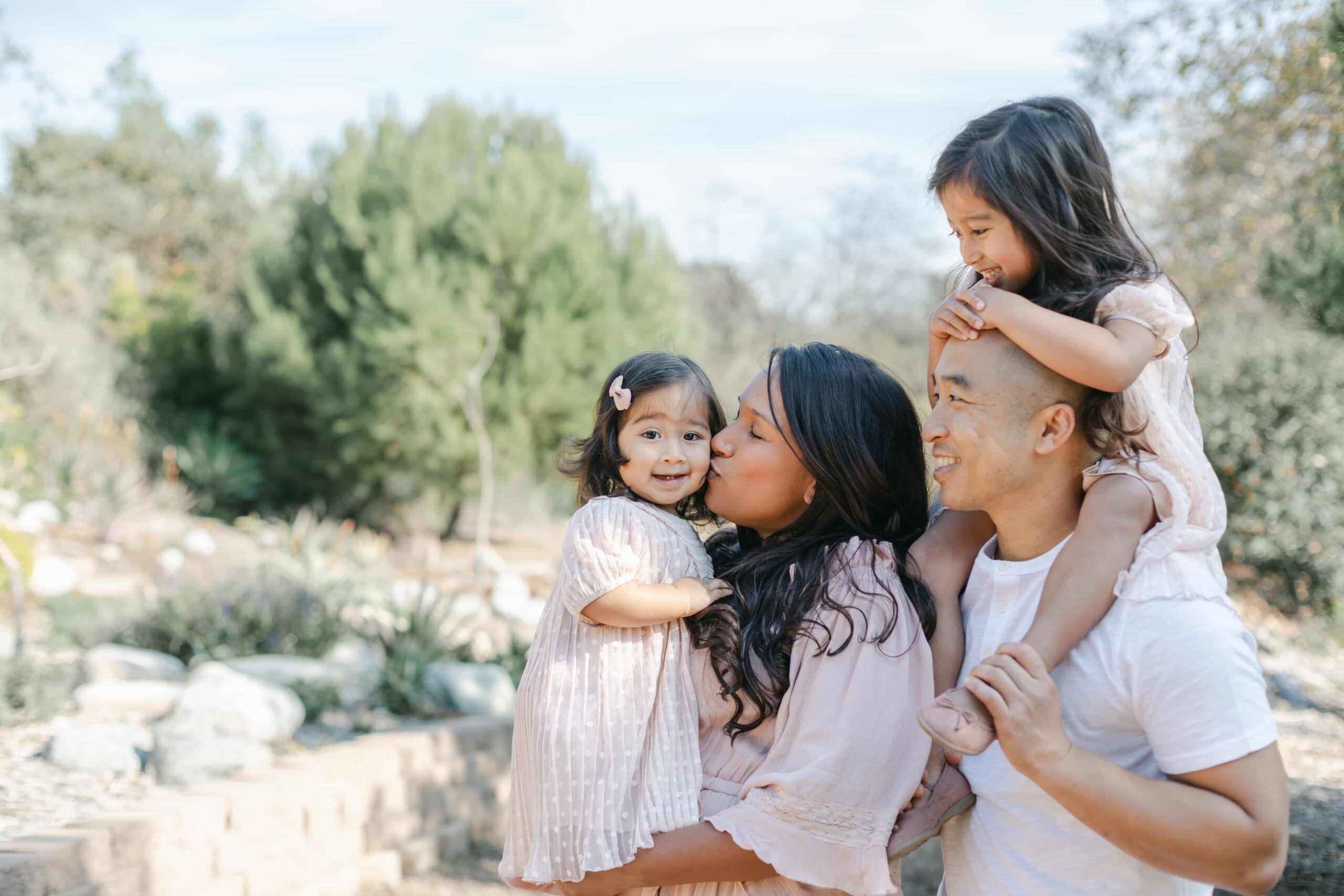 photograph of family outdoors in orange county with young child and 1 year old baby capturing their baby's first year