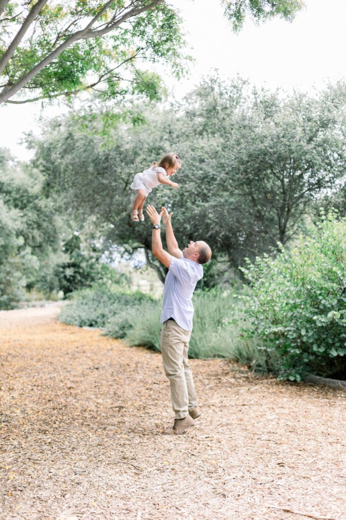 Photograph of man playing with daughter in Orange County park