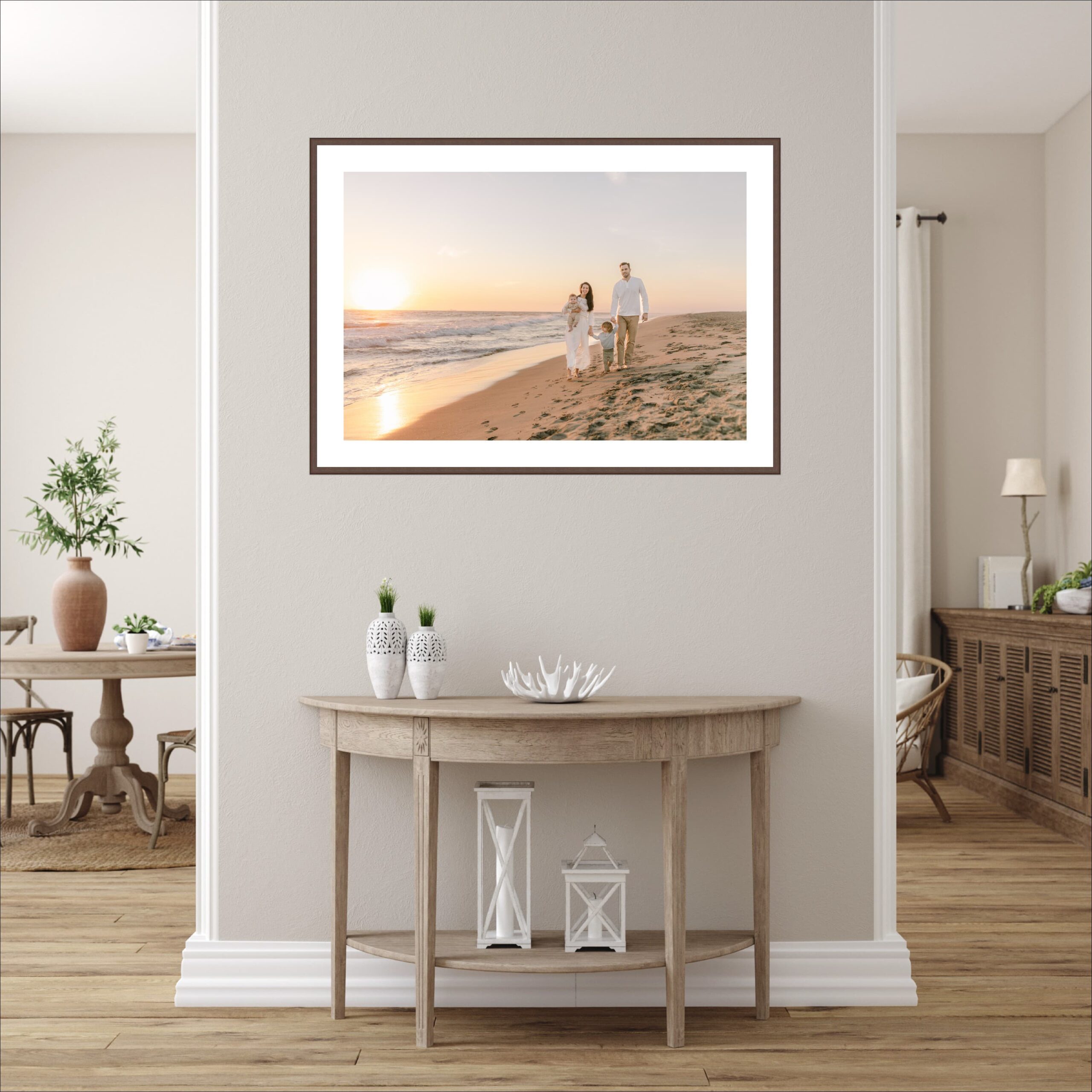 A framed fine art photography image of family walking on a beach at sunset hangs ona. wall above a table thanks to an interior designer in orange county