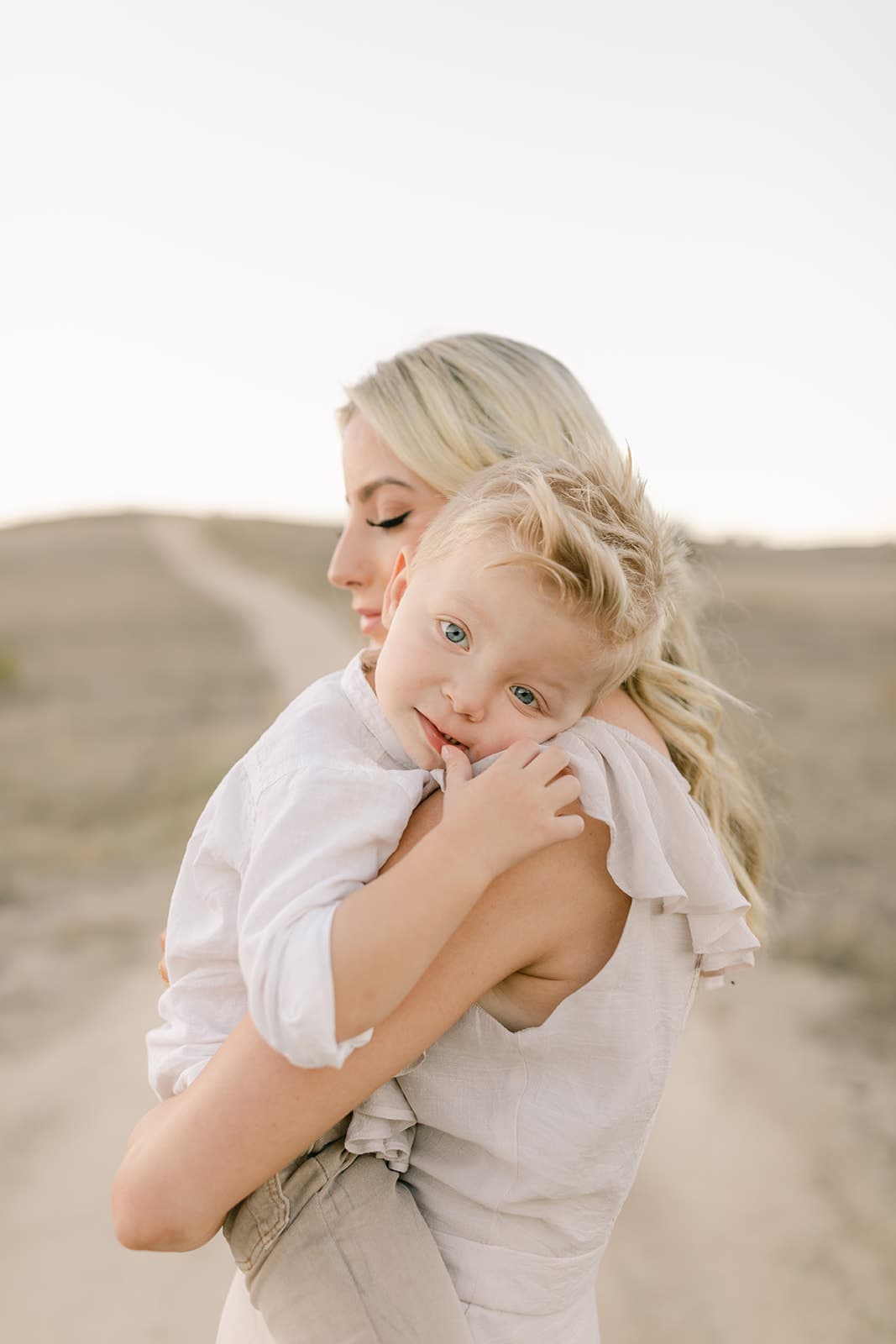 A mother holds her toddler son in a dessert trail after finding Newport Beach Montessori