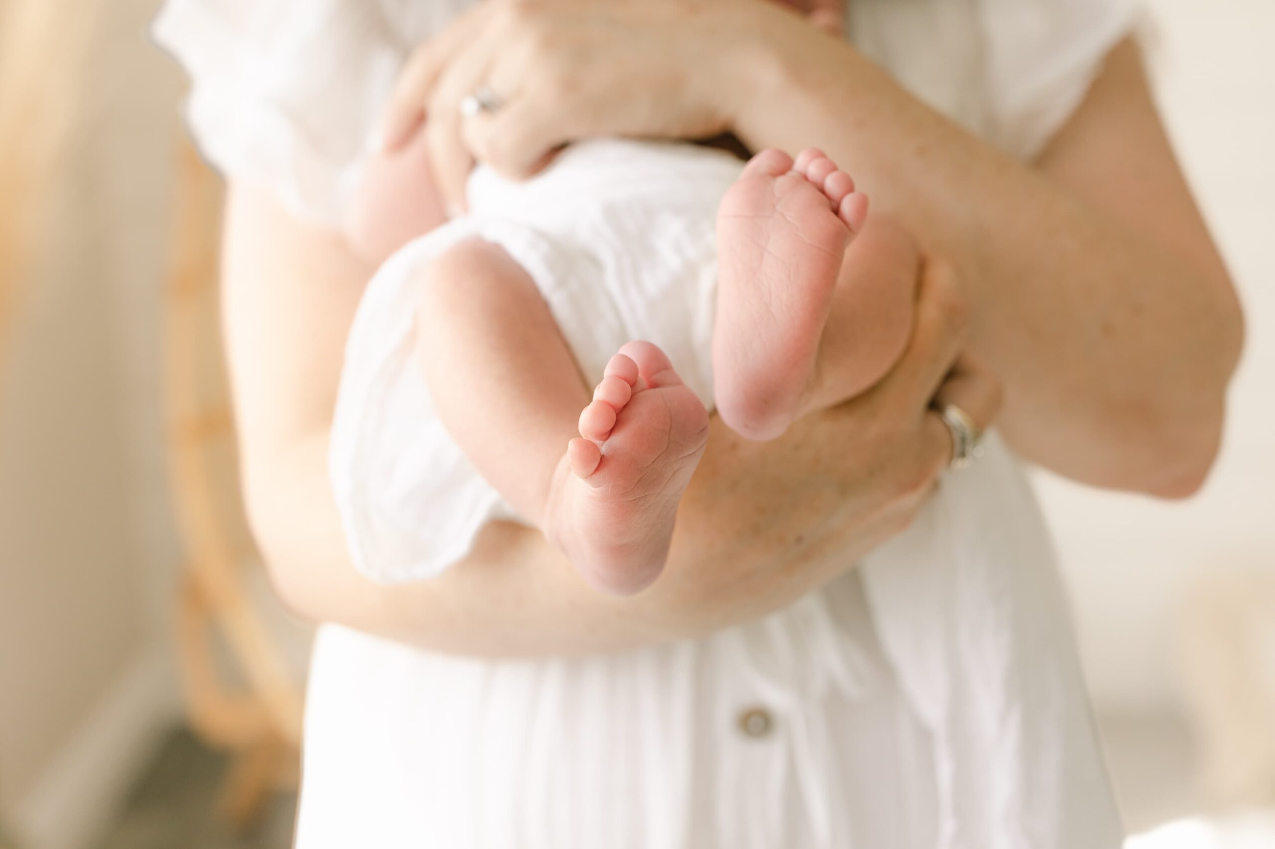 Details of a newborn baby's feet while laying against mom's chest