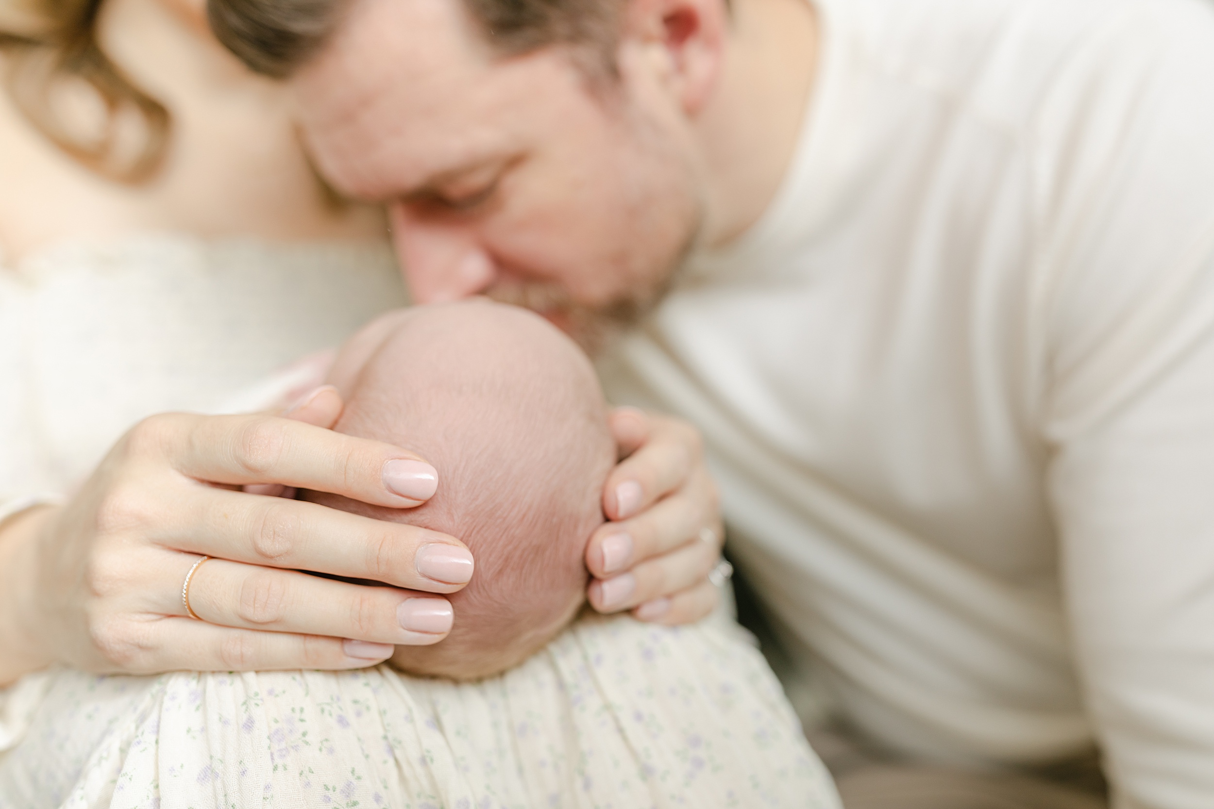 Details of a newborn baby laying in mom's lap as dad kisses its feet before using placenta encapsulation orange county