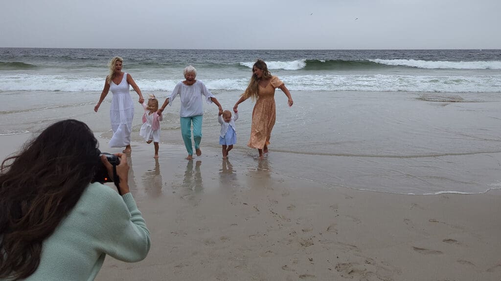 A family plays in the sand on the beach in South Africa while Photographer Reshma Sondagar takes their photo.