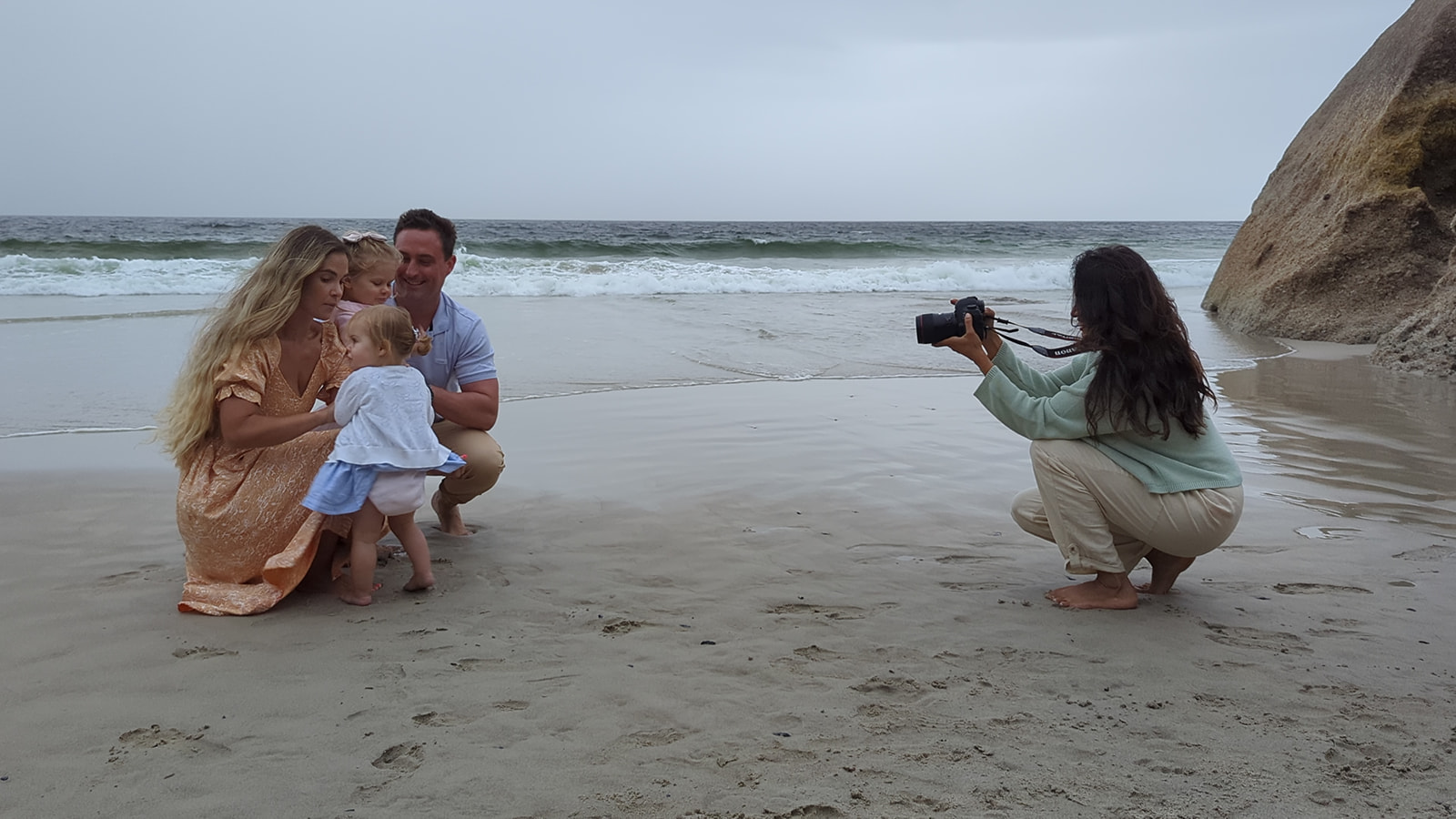 A family poses for a photo on the beach in South Africa while Photographer Reshma Sondagar takes their photo