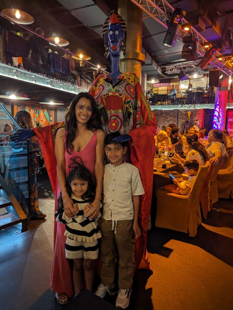 Photo of Reshma Sondagar and her children at a dining experience in South Africa