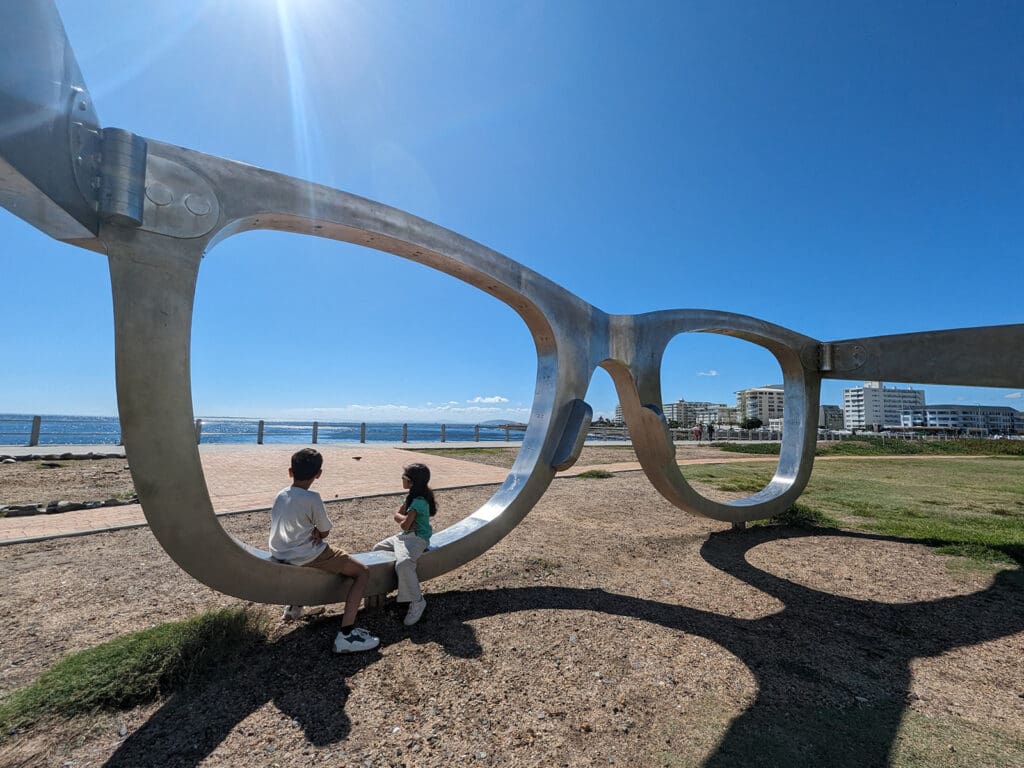 Interactive art in South Africa, the Sondagar children sit in the Mandela Glasses that overlook Robin Island. 